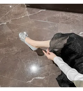 Nahaufnahme glitzernder silberner Strass-Ballerinas mit eleganter Schleife und weicher Sohle