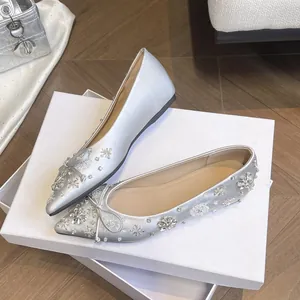 Eleganti ballerine a punta argento con fiocco di strass e dettagli floreali brillanti.