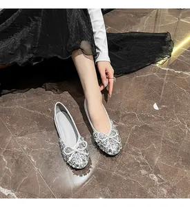 Detailaufnahme von funkelnden Strass-Ballerinas mit zarter Schleife auf Marmorboden