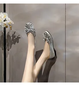 Detailansicht von silbernen Strass-Ballerinas mit Schleife und glitzerndem Finish