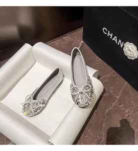 Elegante silberne Ballerinas mit funkelnden Strasssteinen und Schleife in der Detailansicht.