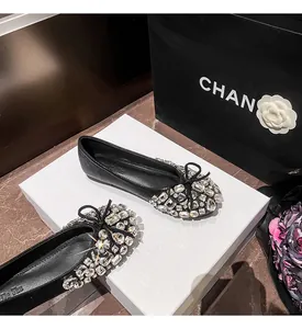 Detailaufnahme von schwarzen Ballerinas mit funkelnden Kristallen und feiner Schleife