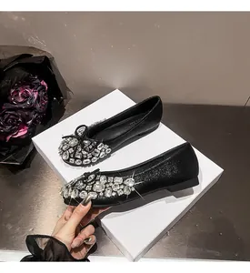 Detailansicht von schwarzen Ballerinas mit funkelnden Strasssteinen und eleganten Schleifen
