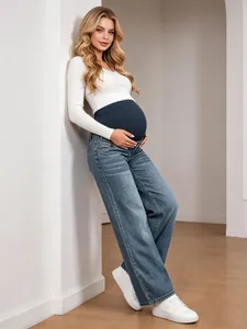 Full-length view of a pregnant woman in blue maternity jeans with high waist support band.