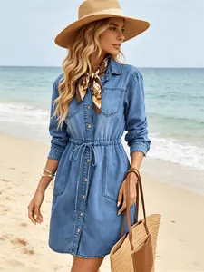 Detailed view of long sleeve denim shirt dress with drawstring waist at the beach
