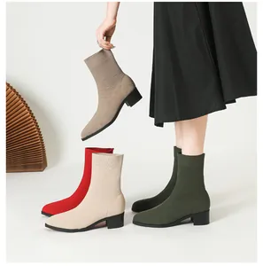 Primer plano de elegantes botines de punto con puntera afilada y tacón ancho de varios colores.