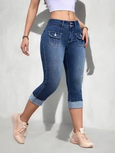 Détail d'un pantalon court en denim extensible à taille haute et coupe ajustée pour femme.