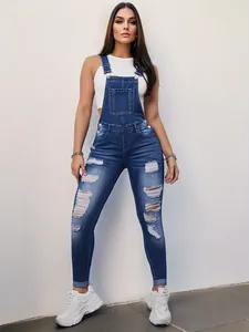Detail view of slim fit distressed denim overalls for women in classic blue wash