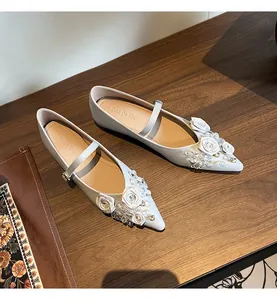 Close-up of elegant pointed-toe Mary Jane flats with floral and crystal details