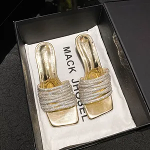 Elegant gold heeled sandals featuring sparkly rhinestone straps and a square toe design.