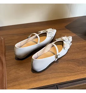 Top view of off-white Mary Jane flats with white rose and crystal embellishments