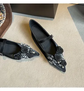 Detailed view of pointed Mary Jane flats featuring satin roses and sparkling rhinestones.