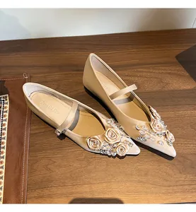 Elegant beige pointed-toe Mary Jane flats featuring satin roses and rhinestone details