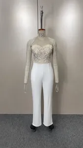 Macro view of an elegant strapless jumpsuit with silver embroidery and white pants