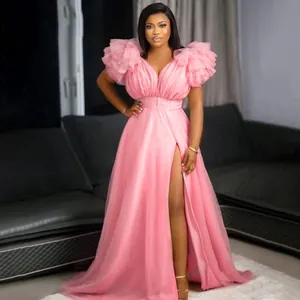 Elegant pink mesh maxi dress featuring dramatic ruffled sleeves and a high slit front design