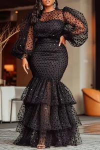 Detailed view of the black flocked polka dot mesh fabric and the layered mermaid hem