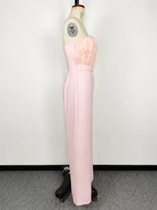 Side view of elegant light pink strapless jumpsuit featuring luxury feather trim detail.