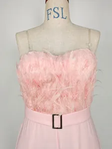 Detail view of elegant pink jumpsuit featuring a feather tube top and belted waist.