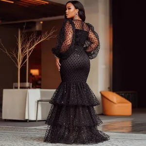 Elegant black polka dot dress with sheer puff sleeves and a tiered mermaid ruffle hem