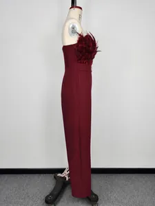 Side view of a burgundy strapless jumpsuit featuring elegant feather trim details.