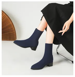 Detalle de una mujer con botines de punto azul marino con puntera y tacón ancho