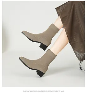 Primer plano de elegantes botines de punto beige con tacón ancho y diseño en punta