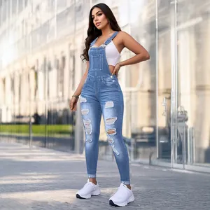 Distressed slim-fit denim overalls for women in a stylish urban outdoor setting