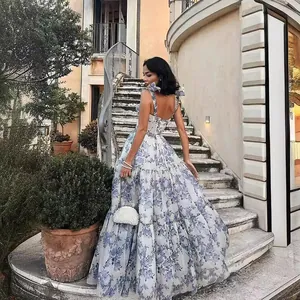 Elegant floral print organza maxi dress worn in a classic European garden setting.