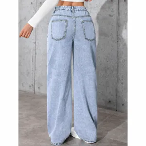 Rear view of light blue high-waisted wide-leg denim jeans against a concrete wall
