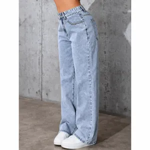 Side view of high-waisted wide-leg light blue denim jeans paired with white sneakers.