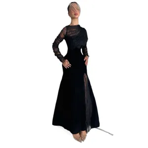 Elegante vestido largo de terciopelo negro con mangas de encaje y abertura.