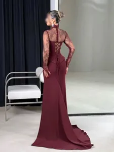 Vue arrière détaillée d'une robe sirène élégante en dentelle bordeaux avec manches et traîne