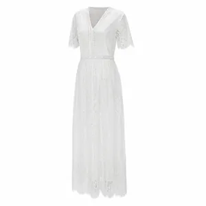Detail view of the intricate floral lace patterns on this elegant white V-neck maxi dress.