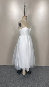 Detail view showing the layered white mesh fabric of a camisole dress on a mannequin