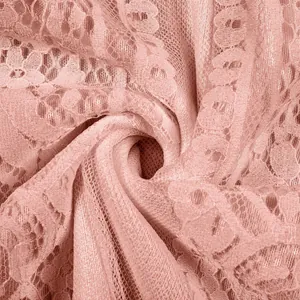 Macro detail of delicate pink floral lace fabric texture for elegant evening dresses