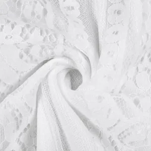 Close-up of elegant white floral lace fabric with intricate mesh texture for wedding dress