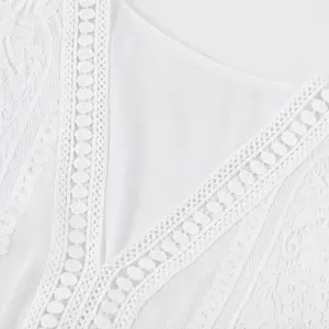Detailed macro shot of white floral lace V-neckline on an elegant tulle wedding dress