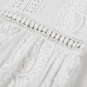 Intricate close-up detail of white lace and tulle fabric on elegant wedding dress
