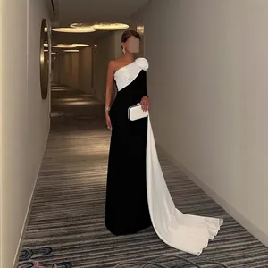 Elegante one-shoulder avondjurk in zwart-wit met prachtig bloemdetail en lange cape.