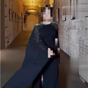 Détail d'une robe de soirée noire avec strass et design élégant de manches cape