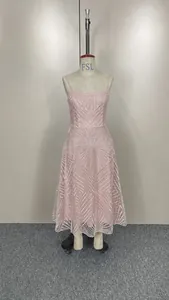 Élégante robe midi rose avec broderies de paillettes géométriques sur un mannequin.