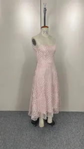 Détail d'une robe rose sans manches avec broderie géométrique argentée.