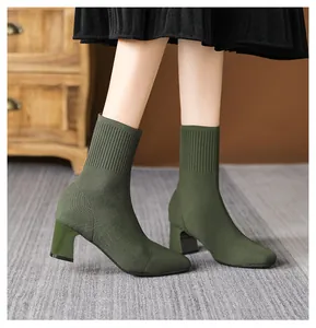 Nahaufnahme der olivgrünen Strick-Sockenstiefel mit Blockabsatz und eckiger Zehenpartie.
