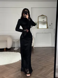 Detailed view of an elegant black evening gown with intricate lace sleeves.