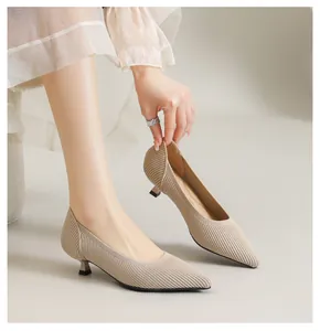 Nahaufnahme von beigen, spitzen Strick-Kitten-Heels, getragen von einem Modell