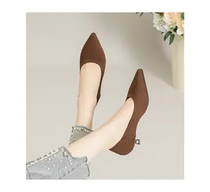 Seitenansicht brauner spitzer Fly-Knit-Stilettos, die im Studio an den Füßen getragen werden