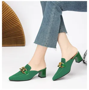 Detailansicht stilvoller grüner Strick-Mules mit Blockabsatz und goldener Kette