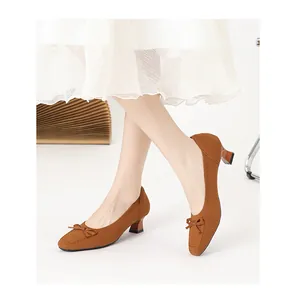 Dettaglio scarpe in maglia marrone con punta quadrata e fiocco con gonna