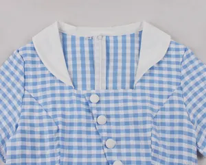 Close-up detail of the white collar and round buttons on blue white checkered dress