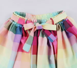 Close-up detail of rainbow checkered skirt with elastic high waist and tied bow